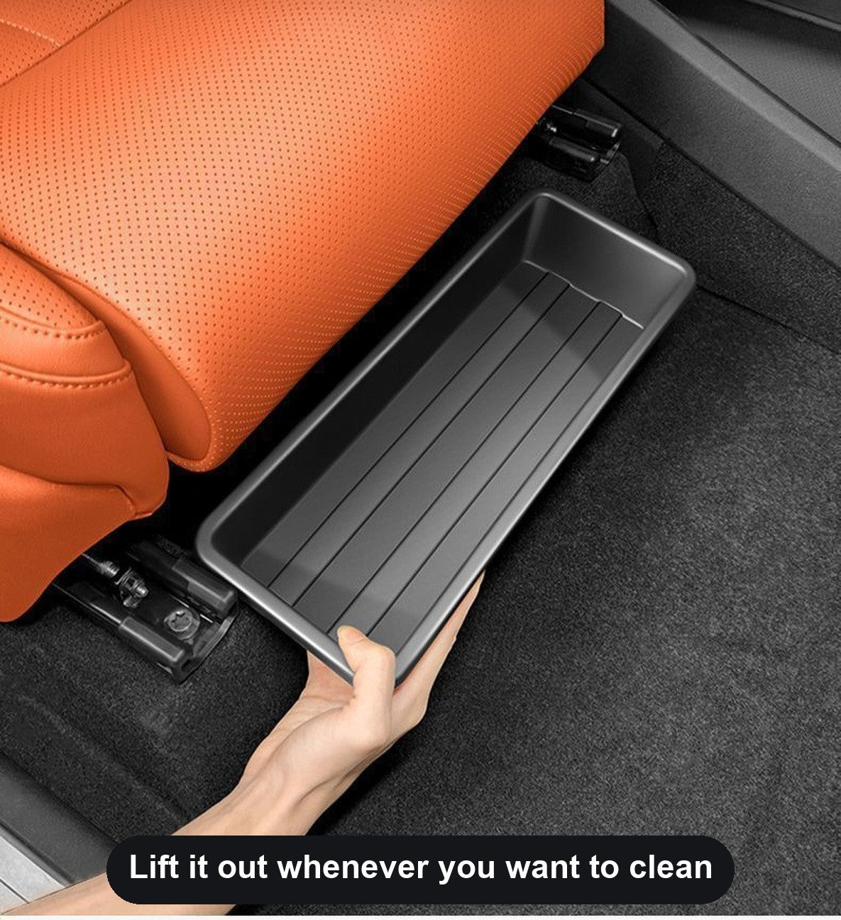 Hand holding the under-seat storage tray beside the front seat rail