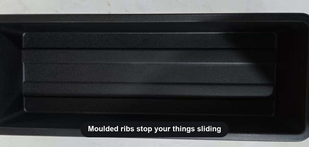 Ribbed floor of the under-seat storage tray stops items sliding